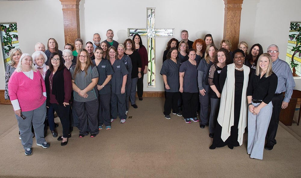 Seasons staff celebrate their faith and pose for a photo in a chapel.