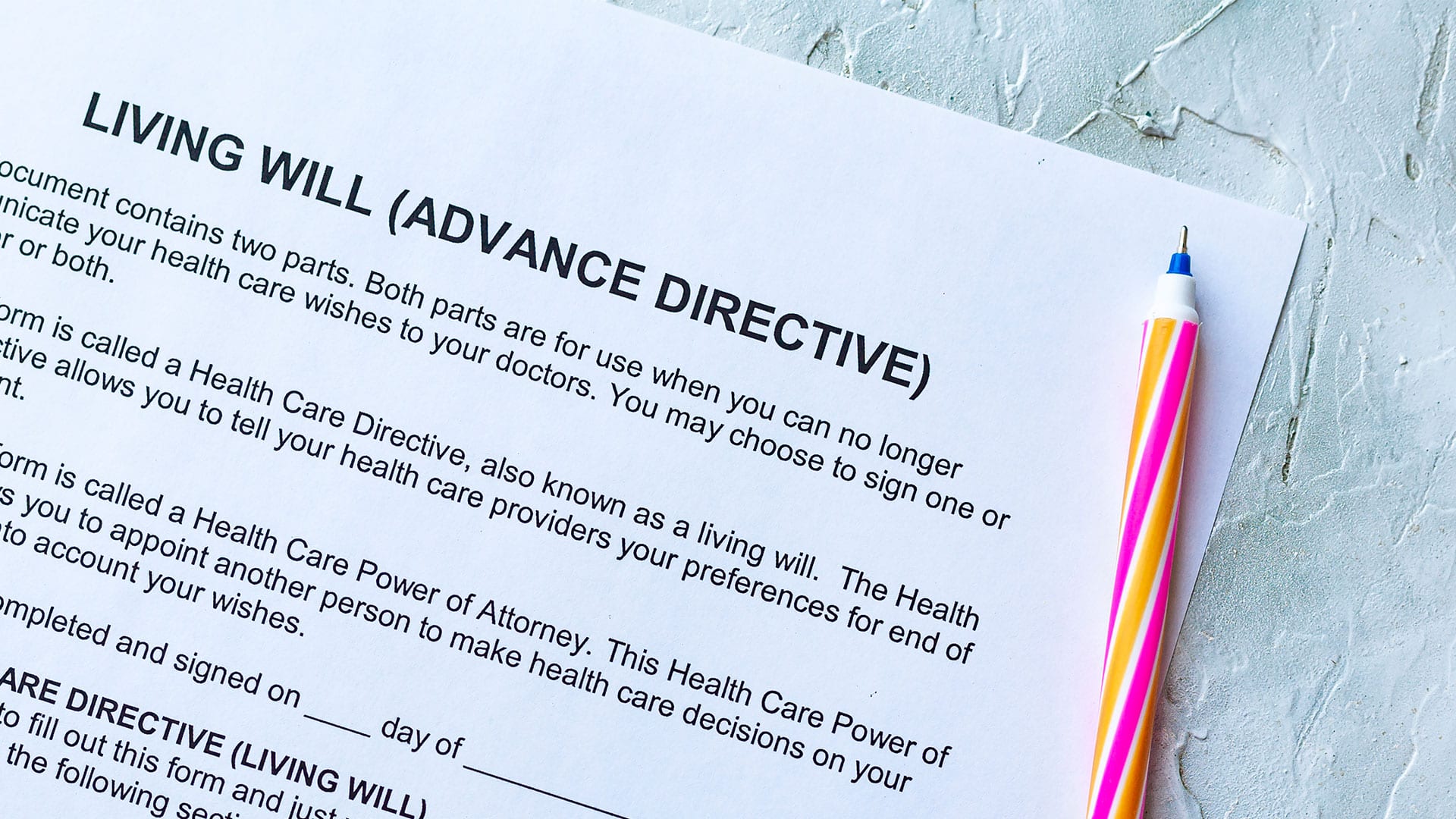 A blank advance directive sits on a table beside a pen.